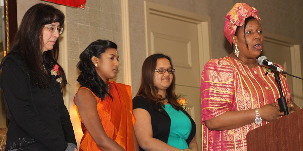 a black speaker wearing african-style attire and three women of color 