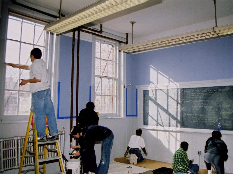 five volunteers painting a classroom 