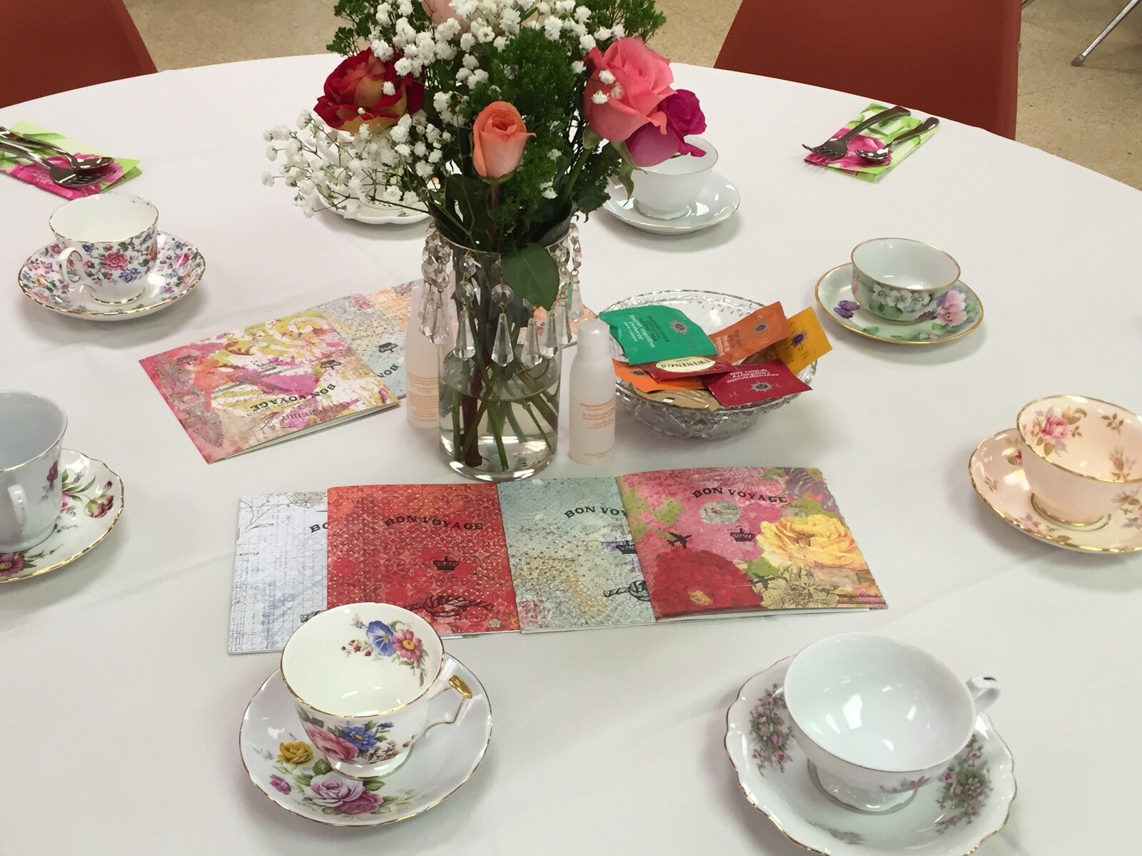 Queen's Tea table set with china tea cups, flowers and floral napkins